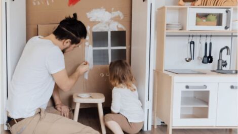 Man and girl painting cardboard.