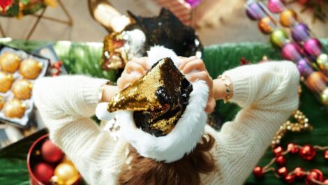 Woman holding Santa Clause hat.