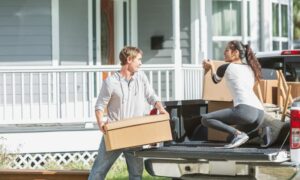 Woman and Man unpacking storage boxes from truck.