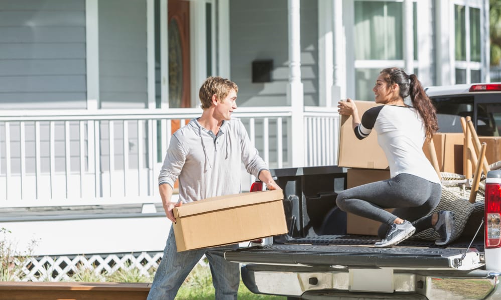 Man and woman unloading boxes from a truck.