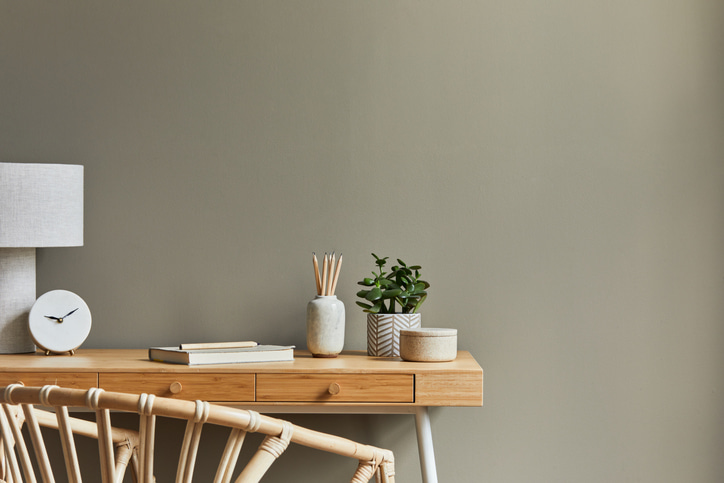 a picture of a wooden desk against a dark wall with simple office supplies.