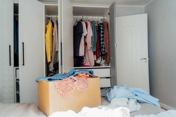 A bedroom with overflowing closet