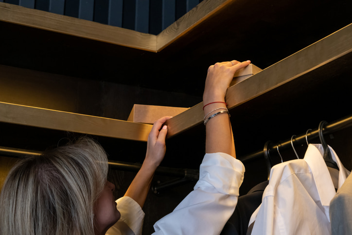 Female grabbing a jewelry box from her closet.