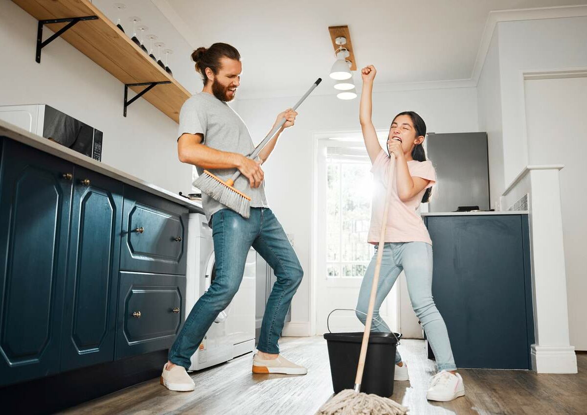 A father and daughter cleaning and using their mops as instruments