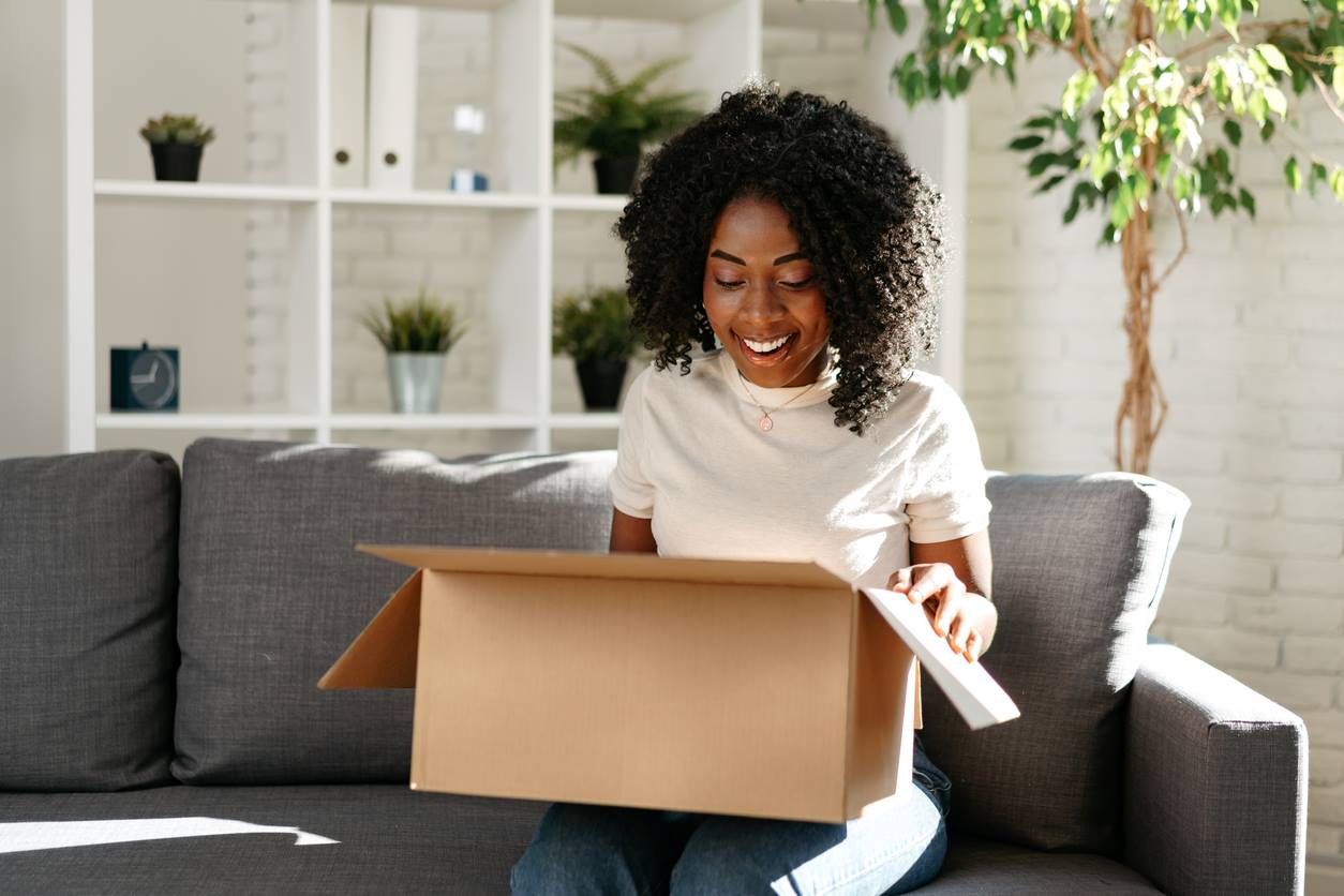 A woman looking a box to pack with her dorm supplies