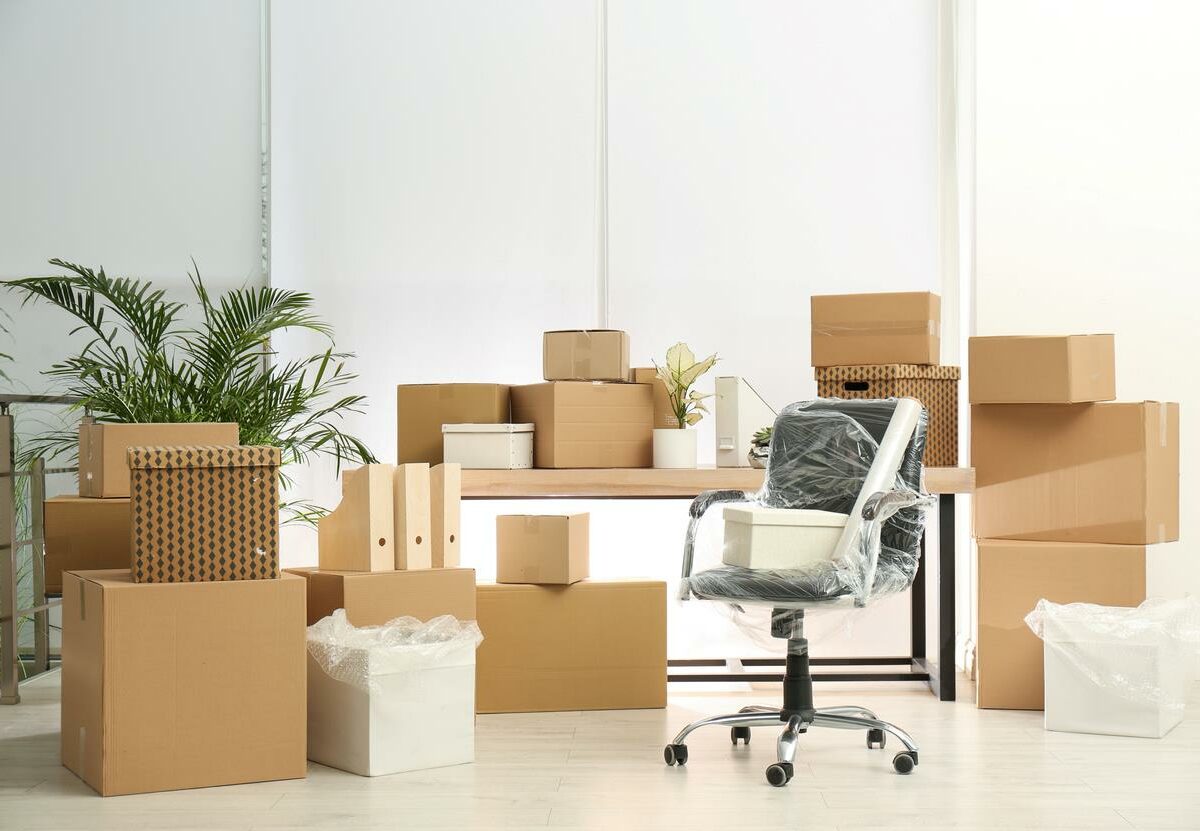 Cardboard boxes and packed chair in an office.