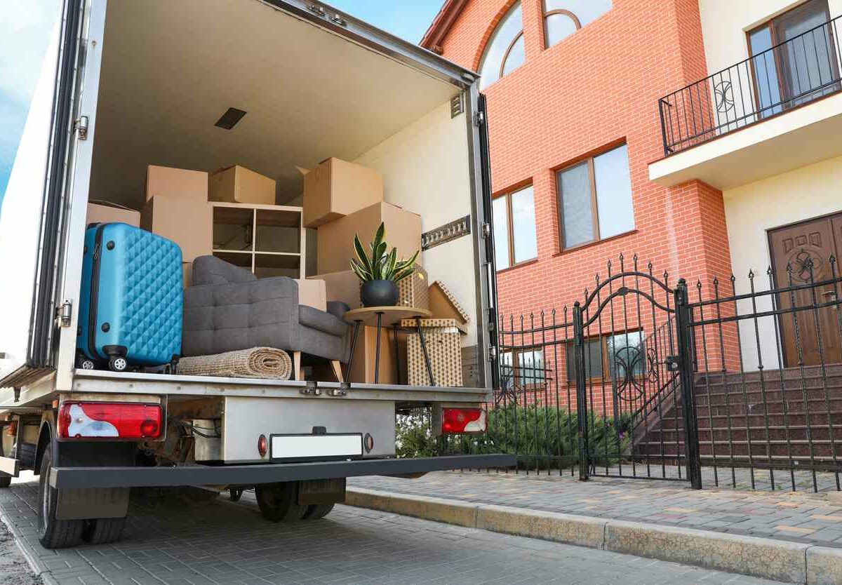 Van full of moving boxes with extra items to put in storage in front of a home.