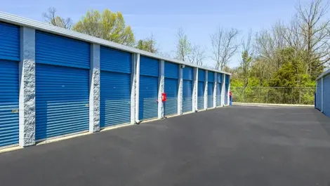 Wide lanes for drive up access storage units with blue doors in Hendersonville, TN, at Devon Self Storage - Shackle Island