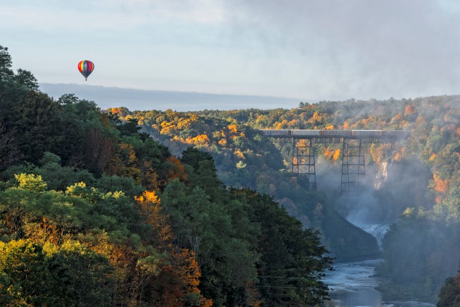 A hot air balloon drifts over the river at Letchworth State Park.