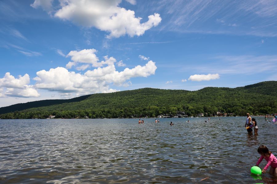 People playing and swimming in the water at Lake George.