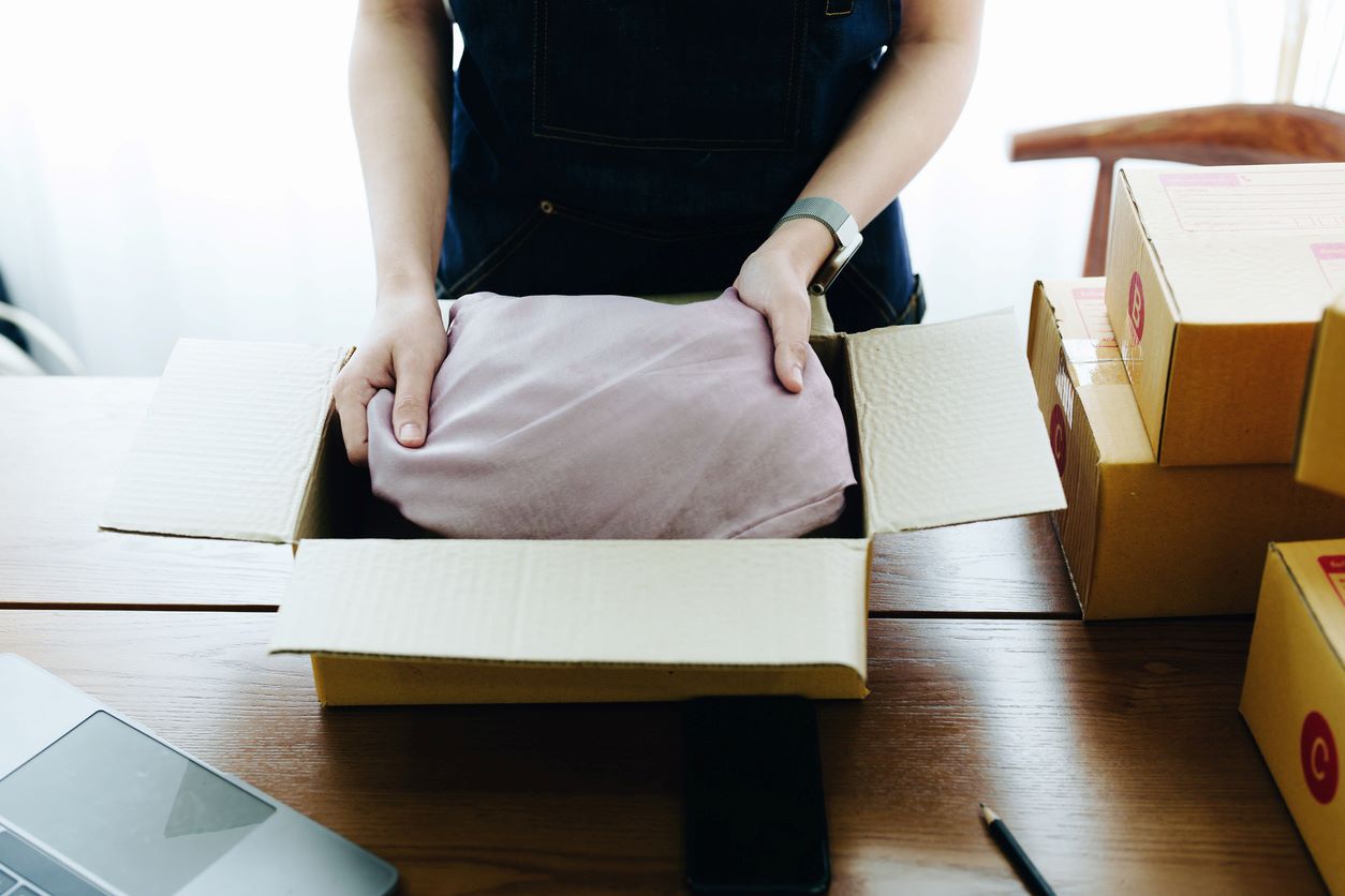 A close-up view of clothes being carefully packed for storage.